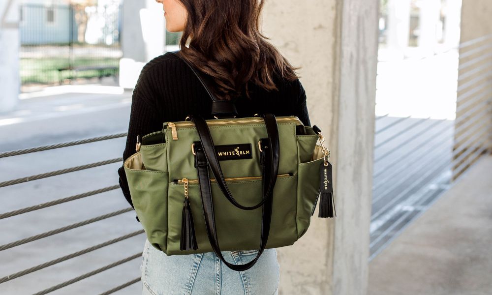gemini mini convertible backpack in green nylon by white elm is worn by a model used for travel and work
