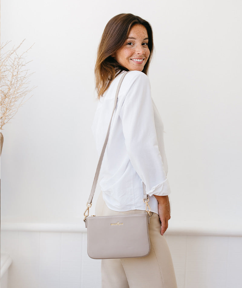 Woman carrying the Taupe Ara Convertible Crossbody Clutch as a handbag