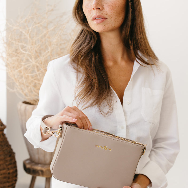 Woman styling the Taupe Ara Convertible Crossbody Clutch with an outfit