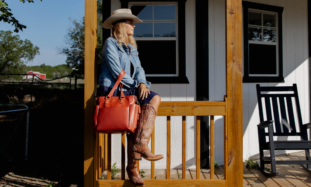 Woman on a porch with a red handbag and cowboy boots