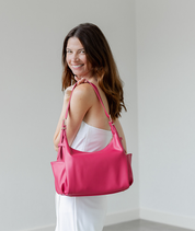 Dragon Fruit Camille hobo bag worn over the shoulder with the strap shortened