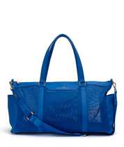 A white elm carmen bright blue mesh and leather duffel bag with double top handles, a detachable shoulder strap, and gold-tone hardware, shown on a plain white background.