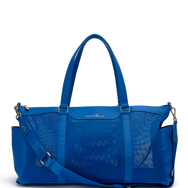 A white elm carmen bright blue mesh and leather duffel bag with double top handles, a detachable shoulder strap, and gold-tone hardware, shown on a plain white background.