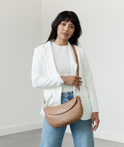 Woman wearing the Almond Emily Crescent bag crossbody