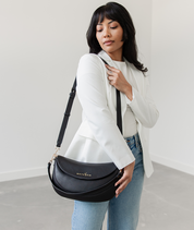 Woman wearing the Black Emily Crescent bag over the shoulder
