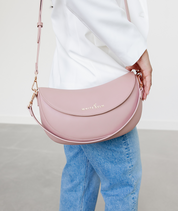 Woman wearing the Dusty Rose Emily Crescent bag over the shoulder