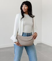 Woman wearing the Taupe Emily Crescent bag crossbody