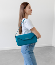 Teal Noemi shoulder bag worn over the shoulder, side profile