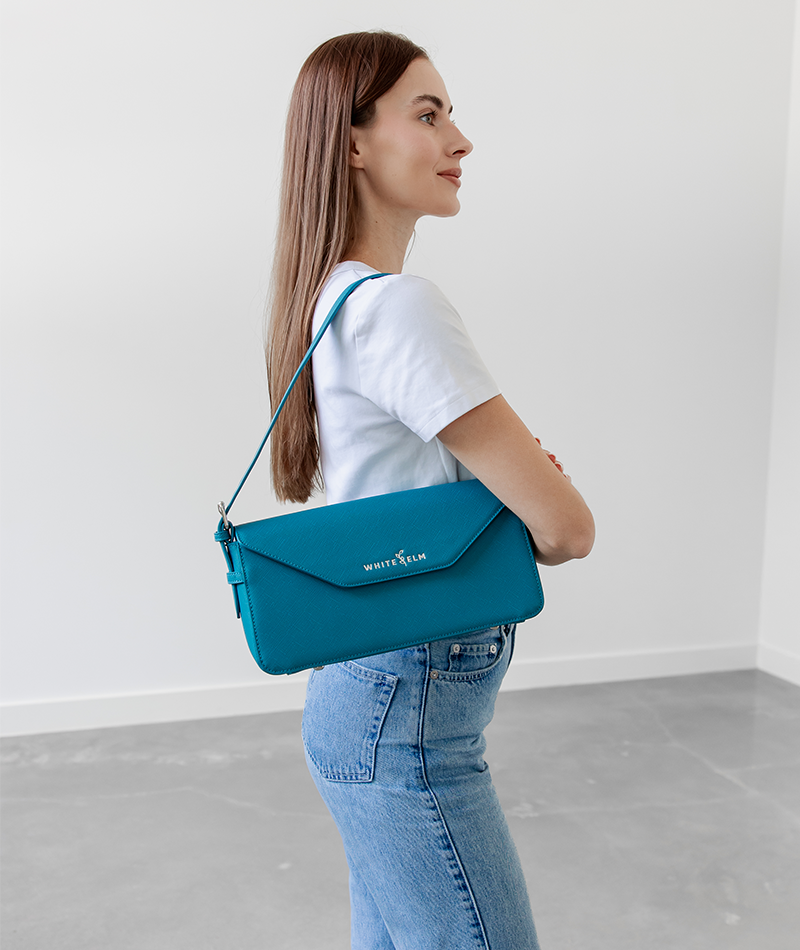 Teal Noemi shoulder bag worn over the shoulder, side profile