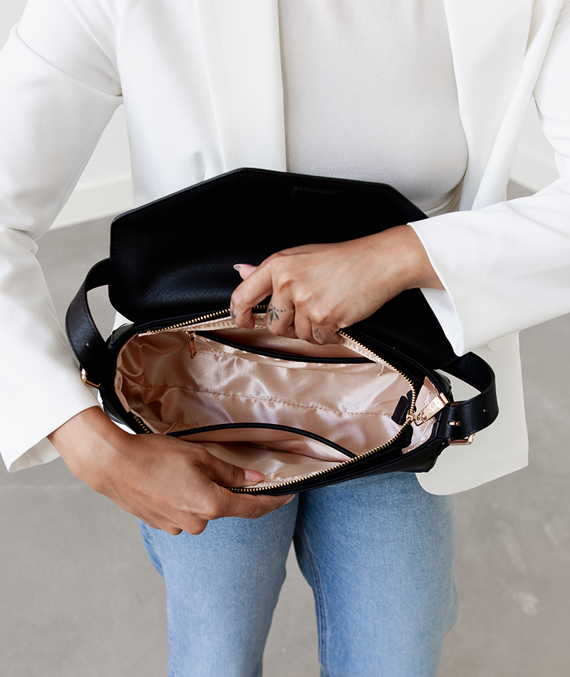 Interior of the black Noemi shoulder bag showing blush pink lining