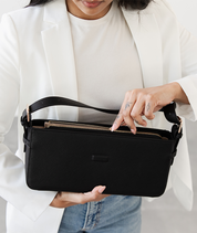 Close-up of the gold zipper pocket on the black Noemi shoulder bag