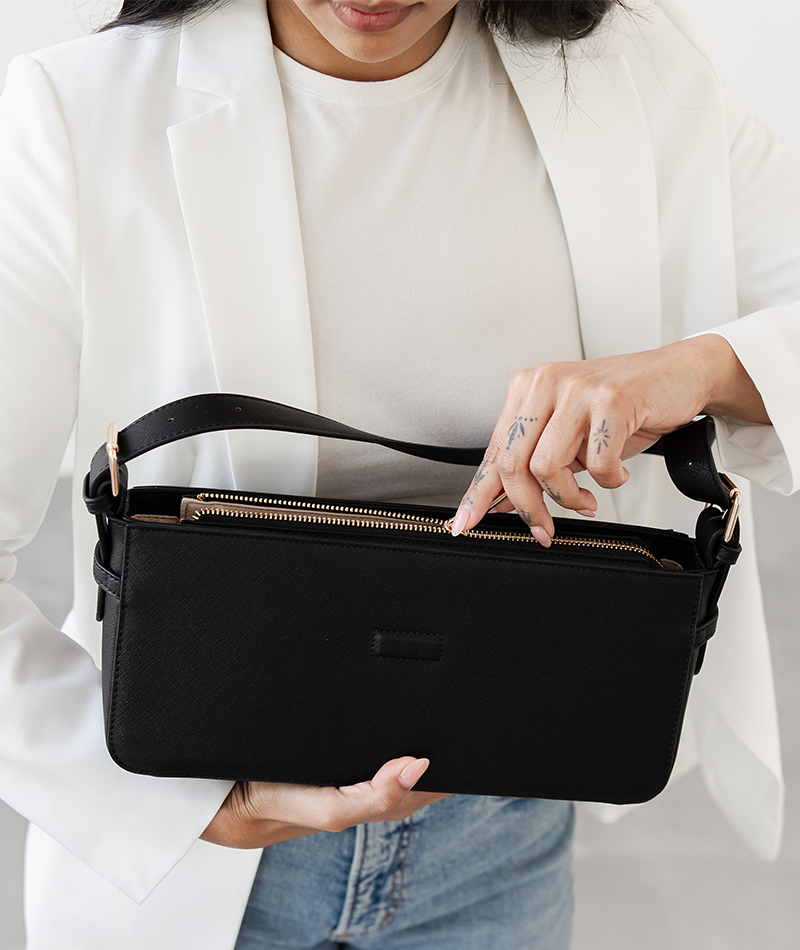Close-up of the gold zipper pocket on the black Noemi shoulder bag