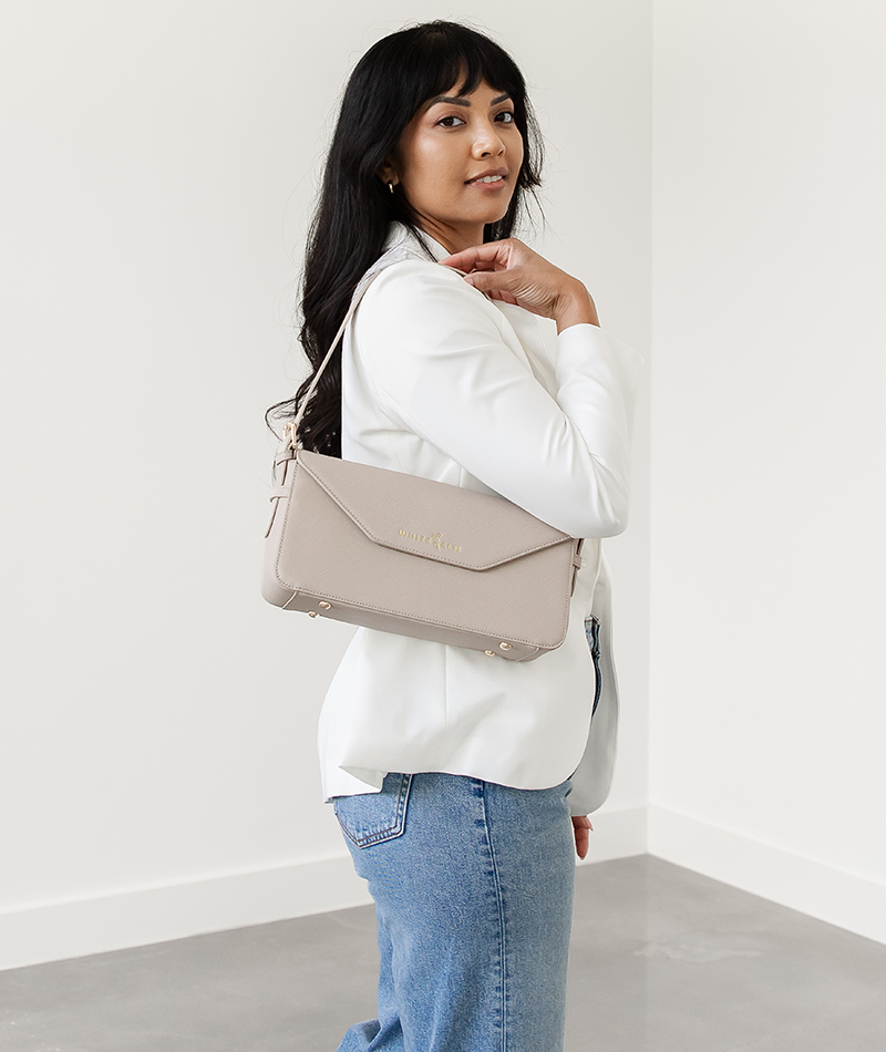 Taupe Noemi shoulder bag worn over the shoulder, looking back
