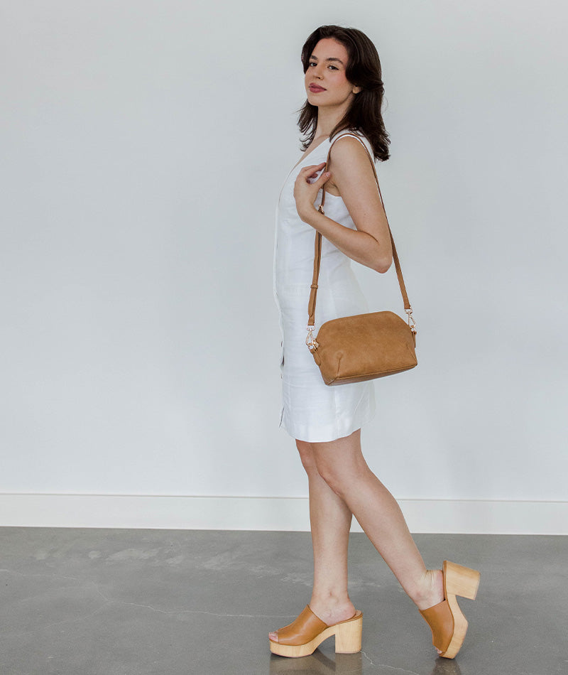 Almond Rosette Crossbody worn over the shoulder (gold hardware)