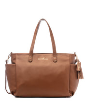 A caramel-colored Aquila tote bag made from vegan leather, featuring two handles, a tassel detail, and side pockets.